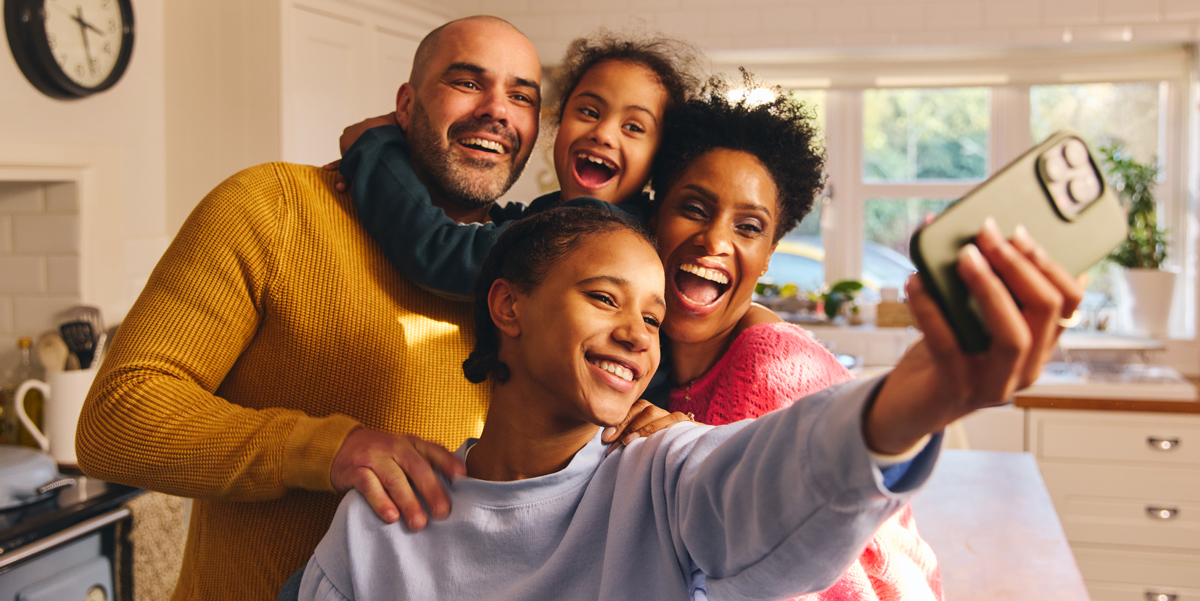 Russo CPA, Saving for Education? Understanding 529 Plans. A family smiles together for a selfie taken by the teenager in the kitchen.