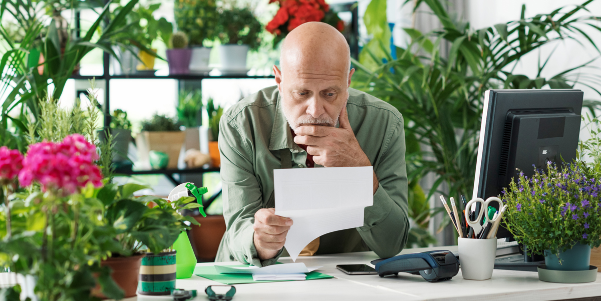 Russo CPA - What To Do if You Missed the Tax-Deadline. A middle aged man and small business owner looks at some paperwork with a worried expression on his face.